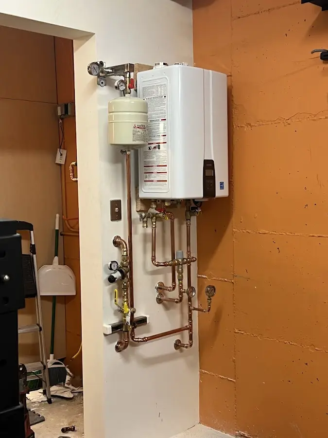 Plumbing technician inspecting water heater connections in Breitung